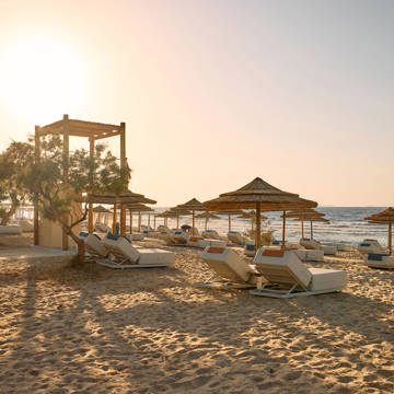 Paralos Kosta Alimia sandy beach with sunbeds, umbrellas and the sea in the background