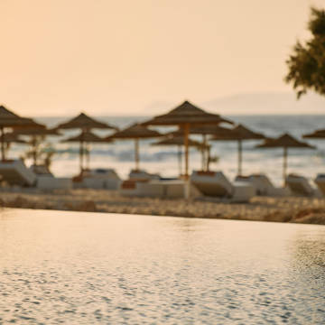 Paralos Kosta Alimia view of the beach sunbeds, umbrellas and the sea from the poolside