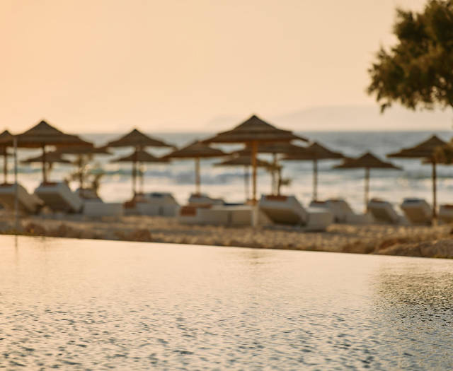 Paralos Kosta Alimia view of the beach sunbeds, umbrellas and the sea from the poolside