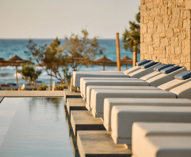 Paralos Kosta Alimia photo of white sunbeds with blue headrests and the sea in the background