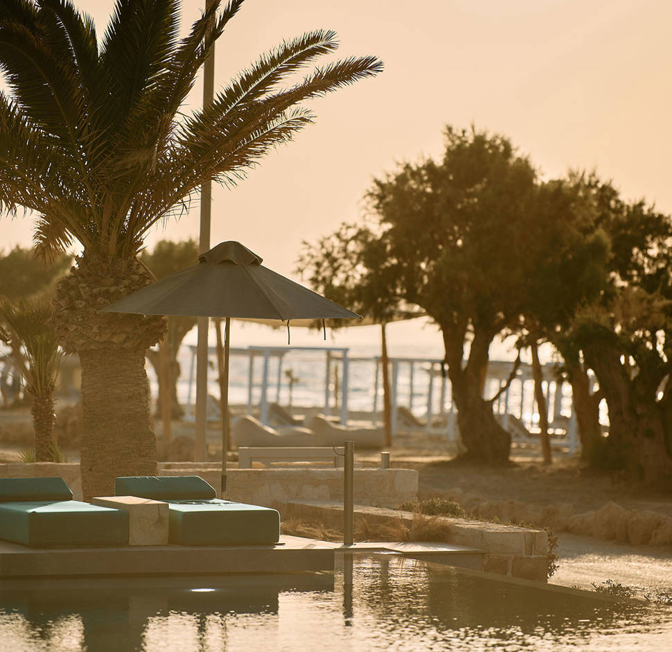 Paralos Kosta Alimia pool's green sunbeds and the beach in the background