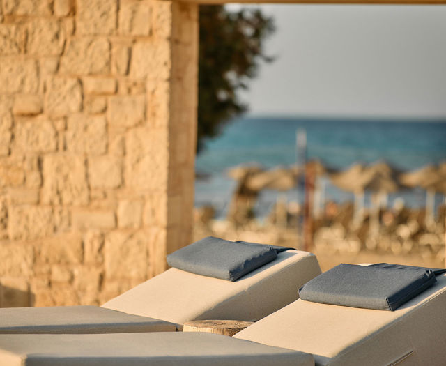 Paralos Kosta Alimia photo focused on two white sunbeds with blue headrests