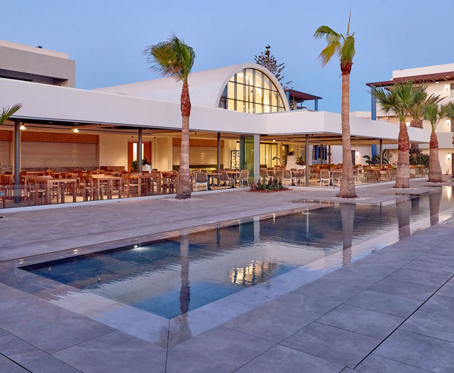 Paralos Kosta Alimia long pool with palm trees on the side and the hotel restaurant in the background