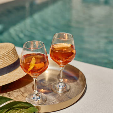 Paralos Kosta Alimia tray with two drinks a straw hat and the pool in the background