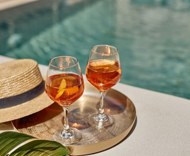 Paralos Kosta Alimia tray with two drinks a straw hat and the pool in the background