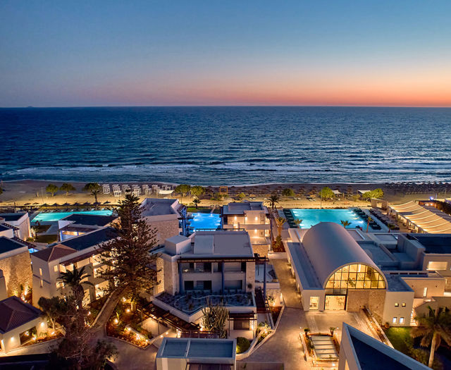 Paralos Kosta Alimia lit up view of the hotel at dusk and the sea in the background