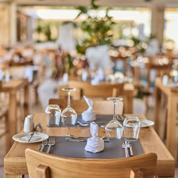 Paralos Kosta Alimia Greek Taverna decorated table with glasses for wine and water and cutlery