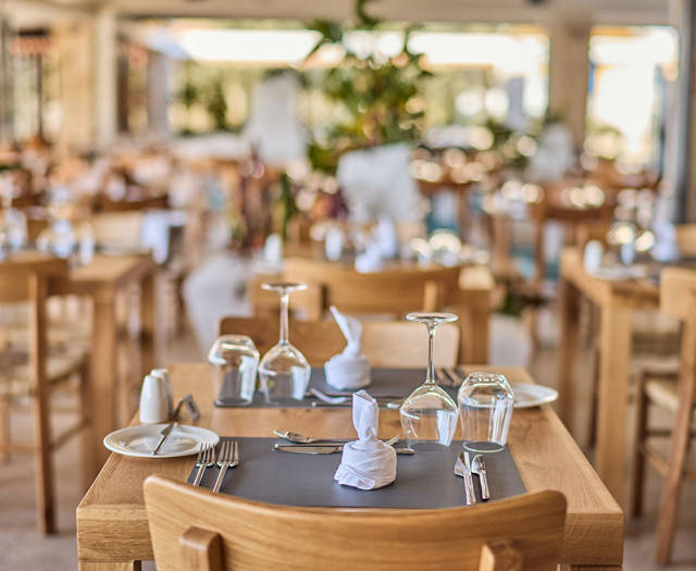 Paralos Kosta Alimia Greek Taverna decorated table with glasses for wine and water and cutlery