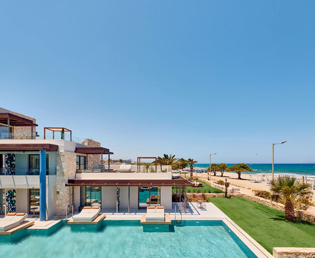 Paralos Kosta Alimia view of the pool, a few sunbeds, small grass field, the beach and the sea